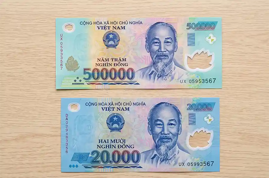 Billets de 500 000 et 20 000 VND à plat sur une table